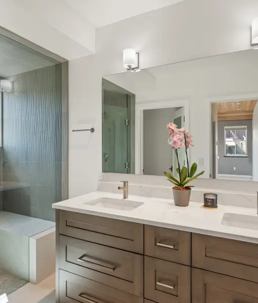 Modern-bathroom-with-dark-double-vanity-white-marble-countertop-mirror-and-walk-in-shower Modern bathroom with dark double vanity, white marble countertop, mirror, and walk-in shower