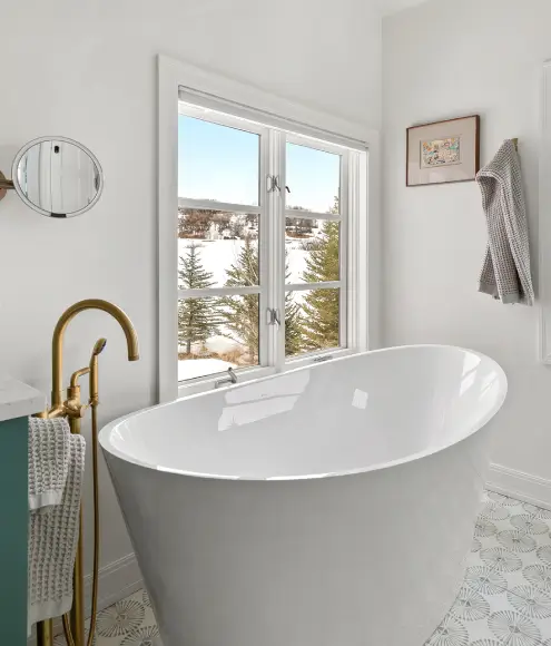 Modern-bathroom-with-freestanding-white-tub-brass-faucet-patterned-tile-floor-and-snowy-mountain-view Modern bathroom with freestanding white tub, brass faucet, patterned tile floor, and snowy mountain view