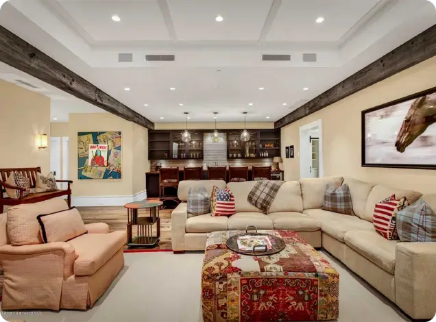 Spacious-basement-entertainment-room-with-sectional-sofa-bar-area-and-rustic-wood-beams Spacious basement entertainment room with sectional sofa, bar area, and rustic wood beams